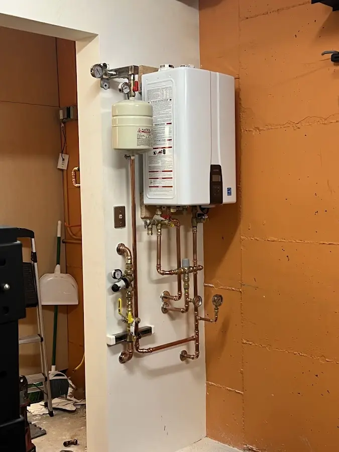 Plumbing technician inspecting water heater connections in Interlaken